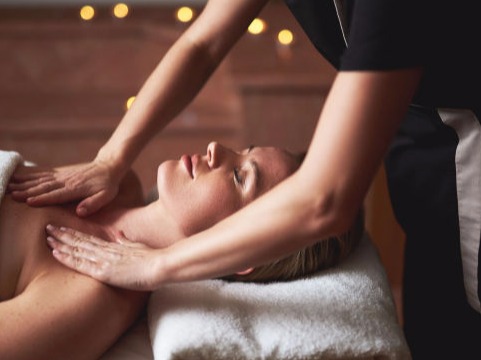 Young woman having a relaxing massage surrounded by aromatic candles